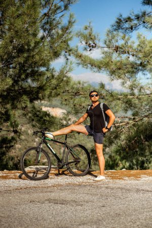 Téléchargez les photos : Un bel homme voyage à travers les montagnes de Turquie à vélo par une journée ensoleillée - en image libre de droit