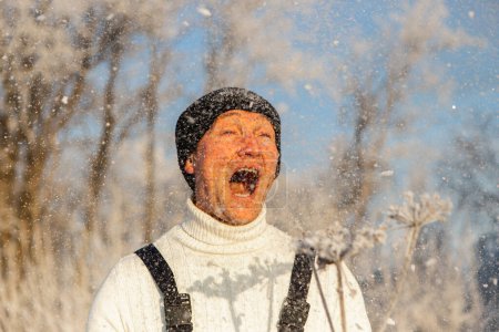 Foto de Un hombre alegre y valiente con ropa negra que se divierte en la nieve blanca en invierno y grita de felicidad y emoción. Fotografía, concepto. Foto de alta calidad. - Imagen libre de derechos