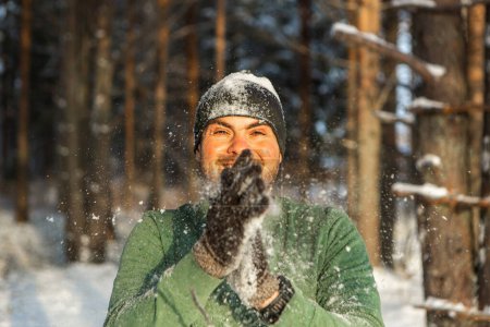 Foto de Hombre atractivo en el bosque de invierno juega bolas de nieve. Wimter concepto de estilo de vida. - Imagen libre de derechos