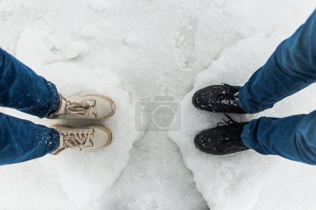 Foto de Piernas abrazando parejas de pie en los hermosos témpanos de hielo invierno nevado en la costa del mar - Imagen libre de derechos
