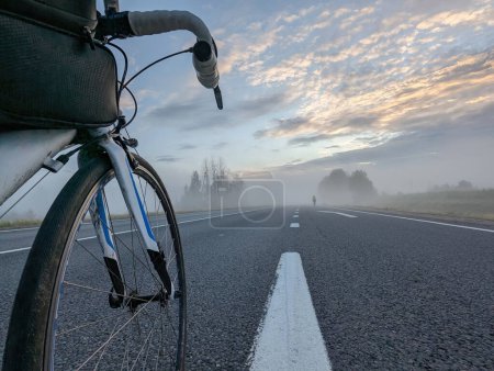 Foto de Bicicleta de carretera en la carretera antes de una carrera de larga distancia en una mañana brumosa. Foto de alta calidad - Imagen libre de derechos