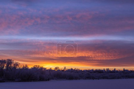 Téléchargez les photos : Coucher de soleil idyllique avec un cirrus coloré au-dessus d'une rivière gelée - en image libre de droit