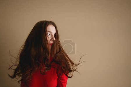 Foto de De cerca joven atractiva mujer de 20 años en cuello alto rojo aislado en el estudio de fondo beige pastel llano. Concepto de vida - Imagen libre de derechos