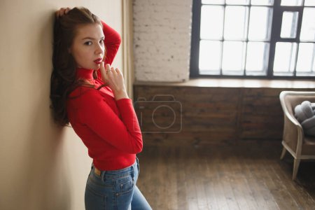 Foto de De cerca joven atractiva mujer de 20 años en cuello alto rojo aislado en el estudio de fondo beige pastel llano. Concepto de vida - Imagen libre de derechos