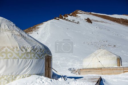 Yurta kazaja en las montañas cerca de Almaty en la nieve en invierno. Casa de los pueblos nómadas en las montañas en invierno.