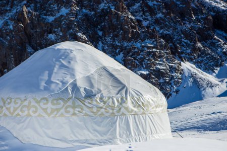 Téléchargez les photos : Yourte kazakhe dans les montagnes près d'Almaty dans la neige en hiver. Maison des peuples nomades dans les montagnes en hiver. - en image libre de droit