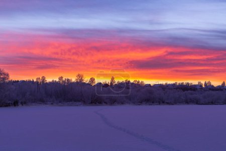 Téléchargez les photos : Coucher de soleil idyllique avec un cirrus coloré au-dessus d'une rivière gelée - en image libre de droit