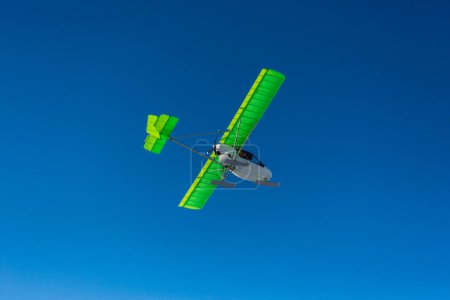 Foto de Ultraligero avión de hélice única con esquís volando sobre el cielo azul en un invierno - Imagen libre de derechos