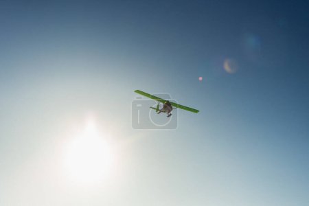 Téléchargez les photos : Avion ultra-léger à hélice unique avec skis survolant le ciel bleu en hiver - en image libre de droit