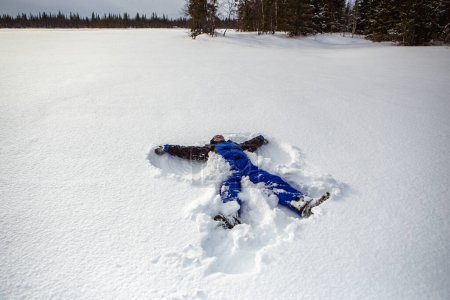 Foto de Hombre alegre divirtiéndose en tundra nevada durante las vacaciones. - Imagen libre de derechos