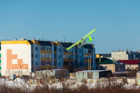 Foto de Ultraligero avión de hélice única con esquís volando sobre el cielo azul en un invierno - Imagen libre de derechos