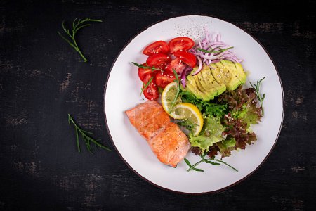 Téléchargez les photos : Alimentation cétogène petit déjeuner. Salade de saumon au four avec légumes verts, tomates, oignons rouges et avocat. Keto, déjeuner paléo. Vue de dessus, vue aérienne - en image libre de droit