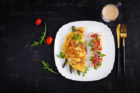 Photo for Keto breakfast. Omelette with cheese, red onion and asparagus on dark table. Italian frittata. Keto, ketogenic lunch. Top view, overhead, copy space - Royalty Free Image