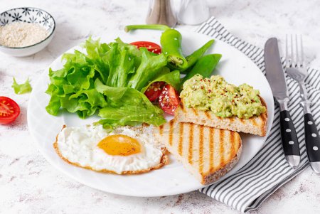 Téléchargez les photos : Fried egg, fresh salad and avocado guacamole sandwiches. Concept of a healthy lifestyle - en image libre de droit