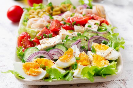 Téléchargez les photos : Healthy cobb salad with ham, cucumber, tomato, olives, feta cheese and eggs. Ketogenic lunch. - en image libre de droit