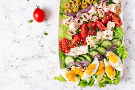 Téléchargez les photos : Healthy cobb salad with ham, cucumber, tomato, olives, feta cheese and eggs. Ketogenic lunch. Top view, overhead - en image libre de droit