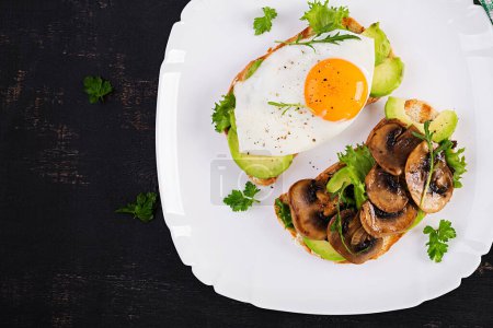 Photo for Sandwiches  with avocado, fried egg and mushrooms  for healthy breakfast or snack. Top view, above - Royalty Free Image