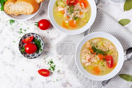Téléchargez les photos : Fish soup with salmon, vegetables and rice in white bowl. Top view, above - en image libre de droit