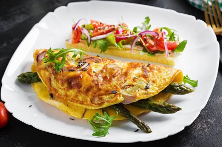 Photo for Keto breakfast. Omelette with cheese, red onion and asparagus on dark table. Italian frittata. Keto, ketogenic lunch. - Royalty Free Image
