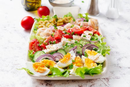 Foto de Healthy cobb salad with ham, cucumber, tomato, olives, feta cheese and eggs. Ketogenic lunch. - Imagen libre de derechos