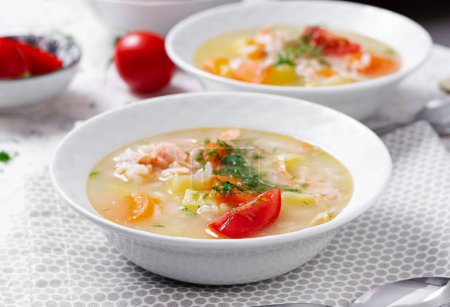 Téléchargez les photos : Fish soup with salmon, vegetables and rice in white bowl. - en image libre de droit