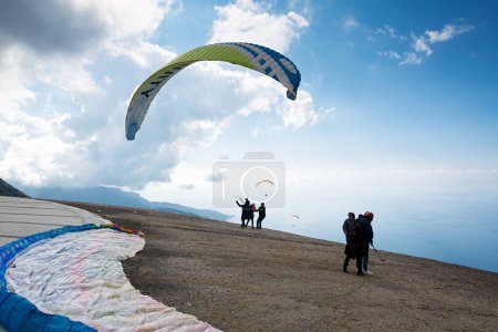 Foto de Babadag. Paragliding start in the air with blue sky, green hills and mountains background near Oludeniz in Turkey - Imagen libre de derechos