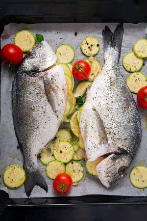 Photo for Raw dorado fish with ingredients for making on a baking sheet. Top view - Royalty Free Image