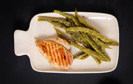 Photo for Chicken fillet cooked on a grill and garnish of green beans. Top view - Royalty Free Image