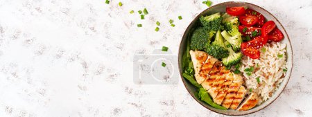 Téléchargez les photos : Delicious buddha bowl with grilled chicken, fresh vegetables and rice on a light background. Top view, banner - en image libre de droit