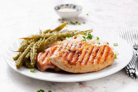 Photo for Chicken fillet cooked on a grill and garnish of rice, green beans. - Royalty Free Image