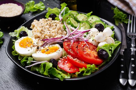 Téléchargez les photos : Healthy breakfast. Savory oatmeal with fresh cucumber, tomatoes, olives, lettuce, mozzarella cheese and boiled egg. Top view - en image libre de droit