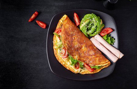Photo for Keto breakfast. Omelette tomato, olives and avocado, ham. Ketogenic diet. Low carb high fat breakfast. Healthy food concept.  Top view - Royalty Free Image