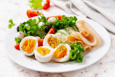 Photo for Ketogenic diet. Boiled eggs, ham, mozzarella cheese and fresh salad.  Keto breakfast. Brunch. - Royalty Free Image