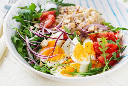 Téléchargez les photos : Petit déjeuner porridge à la flocons d'avoine avec œufs durs, tomates et oignons rouges. Alimentation saine et équilibrée. Nourriture tendance. - en image libre de droit