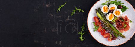 Photo for Keto breakfast. Fried asparagus with boiled eggs and toast with prosciutto or jamon. Ketogenic diet. Healthy food. Top view, banner - Royalty Free Image