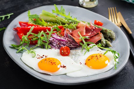 Photo for Keto breakfast. Fried asparagus with roasted eggs and  prosciutto or jamon. Ketogenic diet. Healthy food. - Royalty Free Image