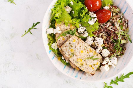 Photo for Healthy salad bowl with quinoa, tomatoes, chicken meatloaf and feta cheese on bowl. Top view, flat lay. Food and health. - Royalty Free Image