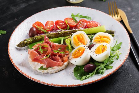 Photo for Keto breakfast. Fried asparagus with boiled eggs and toast with prosciutto or jamon. Ketogenic diet. Healthy food. - Royalty Free Image