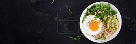 Téléchargez les photos : Petit déjeuner porridge à l'avoine avec oeufs rôtis, kiwi, roquette et graines de lin. Petit déjeuner sain pour réduire le cholestérol. Vue de dessus, plan plat - en image libre de droit