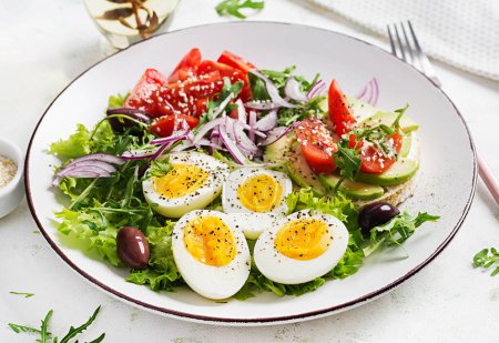 Photo for Fresh  salad with tomato, olives, boiled eggs and and sandwich with  ricotta cheese, avocado. - Royalty Free Image