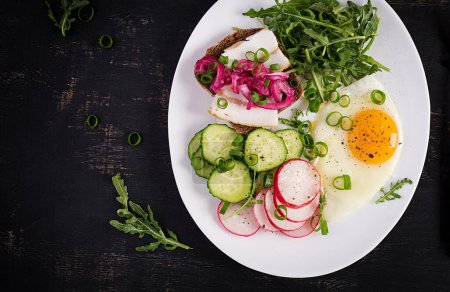 Foto de El desayuno. Huevo frito, ensalada de verduras frescas y sándwich de manteca de cerdo. Dieta Keto. Vista superior - Imagen libre de derechos