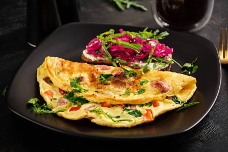 Photo for Breakfast. Omelette with sausage, sweet peppers and sandwich with marinated red onions. Frittata - italian omelet. - Royalty Free Image