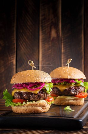Foto de Hamburguesa de res. Sandwich con hamburguesa de res, tomates, queso, pepino en escabeche y lechuga. Hamburguesa con queso. - Imagen libre de derechos