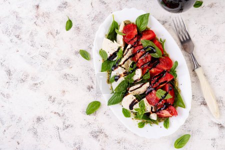 Téléchargez les photos : Caprese tomate salade pour la conception de concept. Fond blanc, gros plan. Concept de nourriture. Vue du dessus - en image libre de droit