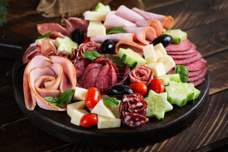 Foto de Coloridas tablas de charcutería y cajas de verduras, carne y queso. Surtido de sabrosos aperitivos o antipasti. - Imagen libre de derechos