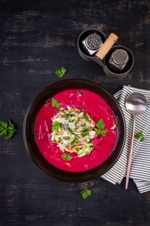 Photo for Cold borscht, summer beet soup with fresh cucumber,  boiled egg and boiled chicken fillet on dark table. Traditional European food, delicious lunch. Top view, overhead - Royalty Free Image