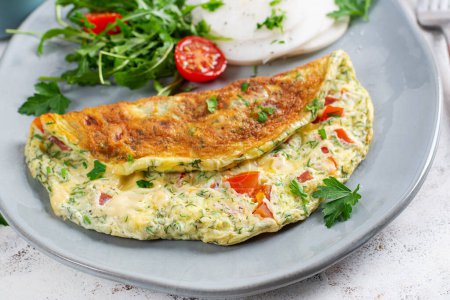 Omelette with tomatoes and salad on plate. Frittata - italian omelet. Keto, ketogenic diet.