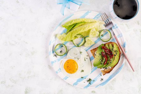 Photo for Romantic breakfast for Valentine's Day. Fried egg and toast with avocado and cream cheese. Top view - Royalty Free Image