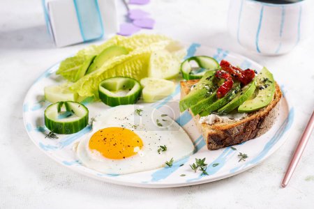 Photo for Romantic breakfast for Valentine's Day. Fried egg and toast with avocado and cream cheese. - Royalty Free Image