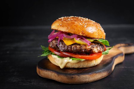 Téléchargez les photos : Hamburger de boeuf. Sandwich au burger de bœuf, tomates, fromage, concombre mariné et laitue. Cheeseburger. - en image libre de droit